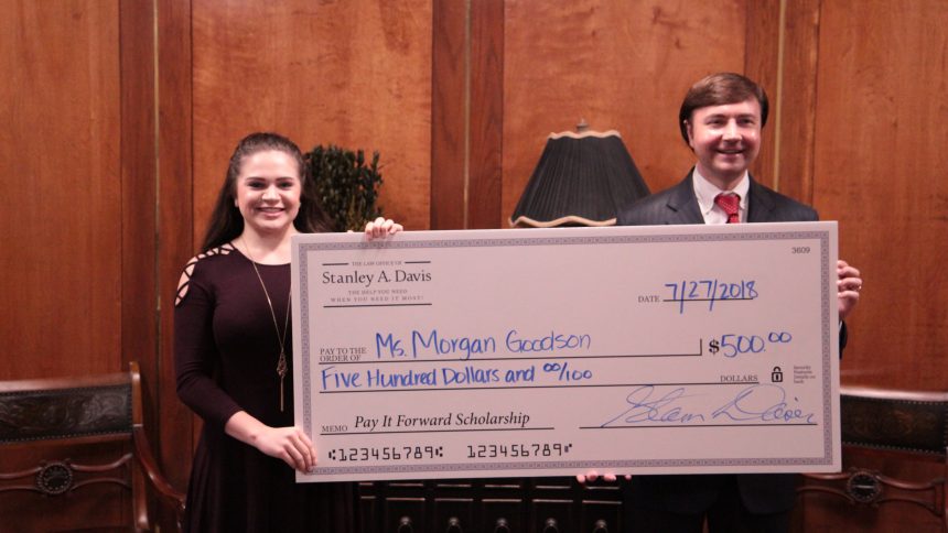 two people holding a large check