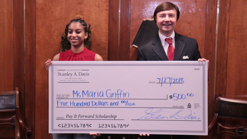 two people holding a large check