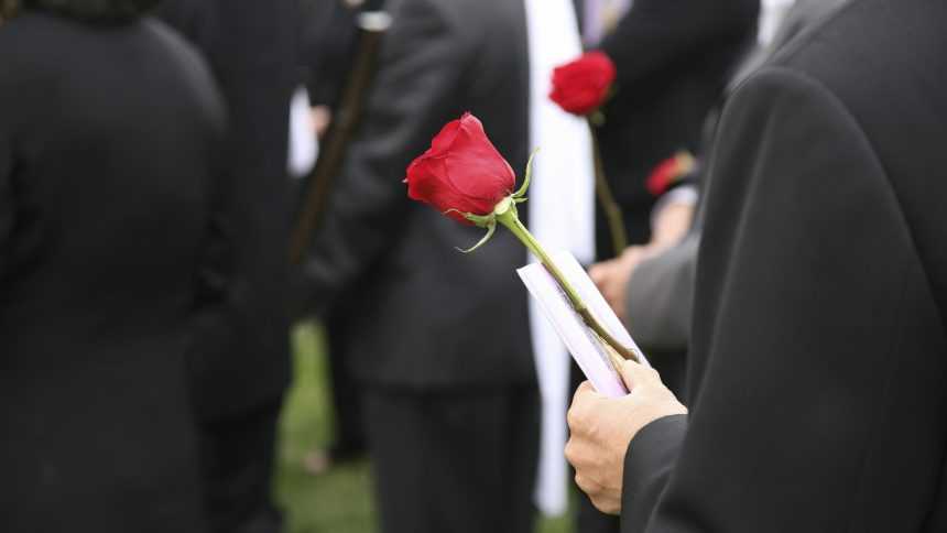 person in black holding a red rose