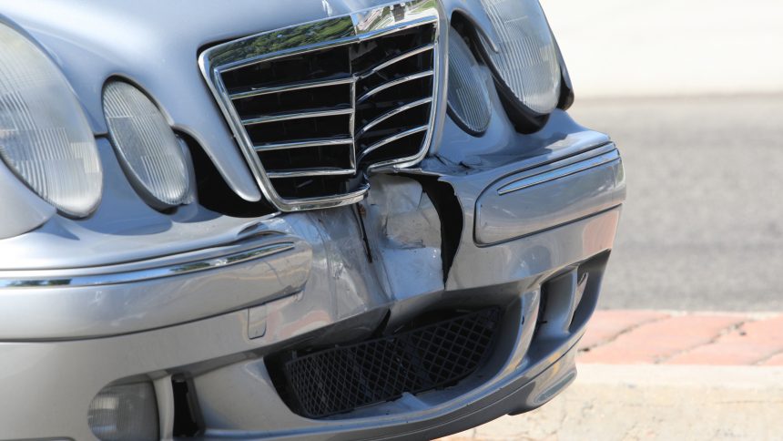 Image of damaged car next to police car